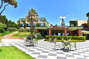 a patio with chairs and tables in front of a building at Pine Beach Belek in Belek