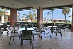 a patio with tables and chairs and palm trees at Pine Beach Belek in Belek