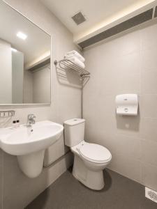 a bathroom with a sink and a toilet and a mirror at Sandpiper Hotel Singapore in Singapore +23 photos