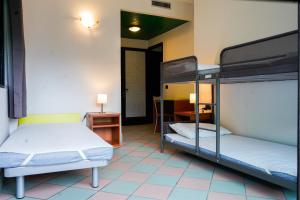 two bunk beds in a room with a hallway at Valsesia Hostel in Scopello