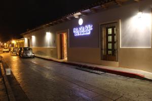 a sign on the side of a building at night at Hotel Palace Inn SCLC in San Cristóbal de Las Casas