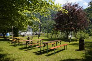 a row of picnic tables and swings in a park at Valsesia Hostel in Scopello
