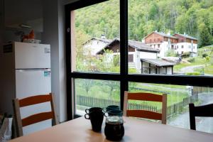 a kitchen with a table and a large window at Valsesia Hostel in Scopello +20 photos