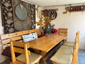 a dining room with a wooden table and two dolls at Mardoyan's Guest house in Gavarr