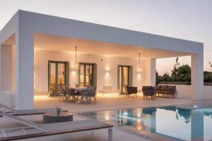 a villa with a swimming pool and a house at Alkinoe Villa Paros in Isterni