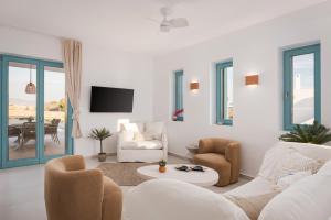 a living room with white furniture and a table at Alkinoe Villa Paros in Isterni