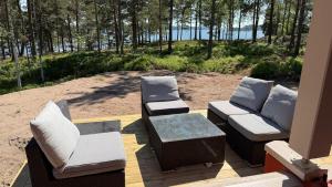 a patio with two couches and a table and chairs at Villa Predium renovated cottage for four in Raseborg