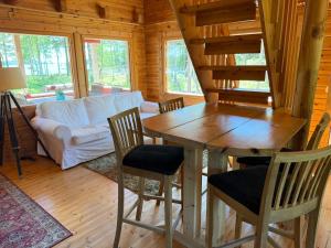 a living room with a wooden table and chairs at Villa Predium renovated cottage for four in Raseborg
