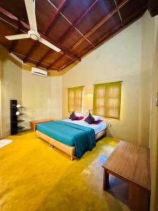 a bedroom with a bed and a ceiling fan at My Village in Tissamaharama +242 photos