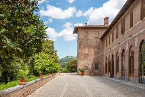 an alleyway leading to an old stone building at Tenuta Bichi Borghesi in Monteriggioni