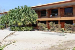 a large building with a palm tree in front of it at Hotel Doña Marta in Nicoya