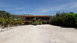 a house on the beach with a gravel driveway at Hotel Doña Marta in Nicoya