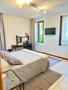 a bedroom with a bed and a tv on the wall at Villa Trevisi - ROOMS -free parking in Treviso