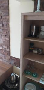 a kitchen with wooden shelves with pots and pans at Apartament Sea Planet Mielno Centrum - parking w cenie pobytu in Mielno