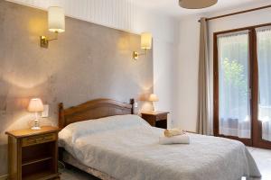 a bedroom with a bed and two lamps and a window at Ferme Auberge Du Roc in Saint-Pompont