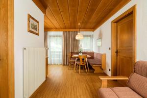a living room with a table and a dining room at Residence Rottonara in Corvara in Badia