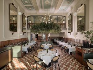 ein Restaurant mit Tischen und Stühlen und einem Kronleuchter in der Unterkunft ON Residence - Small Luxury Hotels of the World in Thessaloniki