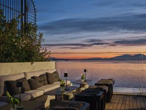 eine Terrasse mit Sofas und Blick auf das Wasser in der Unterkunft ON Residence - Small Luxury Hotels of the World in Thessaloniki
