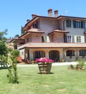 a large house with a flower pot in the yard at Il colle dei Frati in Sinalunga