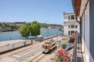a bus is parked on a street next to a building at Miragaia - Riverside Suites - Adults Only in Porto