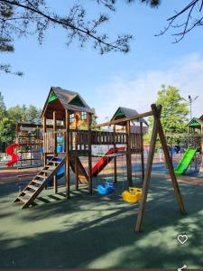a playground with wooden play equipment in a park at Relax inn in Kobuleti