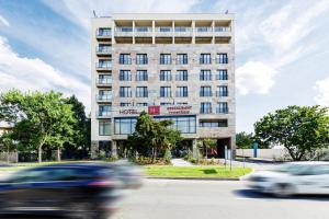 a building with cars speeding by in front of it at In Grand Hotel & SPA in Bucharest