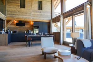 a living room with a table and a kitchen at Splendide châlet neuf avec jaccuzzi in Bolquere Pyrenees 2000