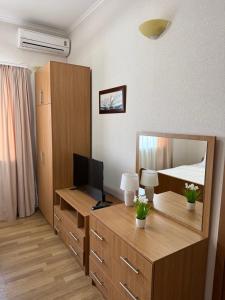a bedroom with a desk with a television and a bed at Otel delfin in Karolino-Buhaz