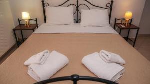 a bed with white towels on it with two lamps at Nice & Cosy apartment in Igoumenitsa in Igoumenitsa