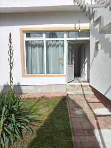 a white house with a door and a window at Green Thuja House in Făgăraş +3 photos