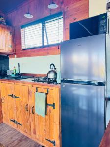 a kitchen with a stainless steel refrigerator and wooden cabinets at Matilo Cabins - Cactus Deck with Hot-tub and Fireplace in Calitzdorp +33 photos