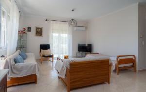 a living room with two beds and a tv at Nice & Cosy apartment in Igoumenitsa in Igoumenitsa