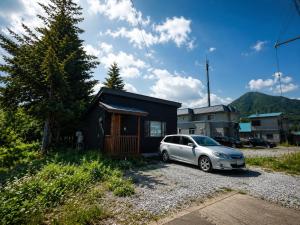a car parked in front of a tiny house at Japow KiichiGo! in Kimobetsu