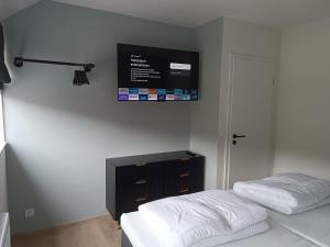 a bedroom with a bed and a tv on the wall at Chez nous a Durbuy in Durbuy