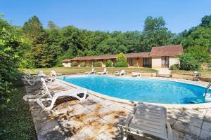 a swimming pool with lounge chairs and a house at Ferme Auberge Du Roc in Saint-Pompont