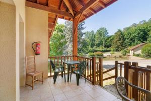 a patio with a table and chairs on a porch at Ferme Auberge Du Roc in Saint-Pompont