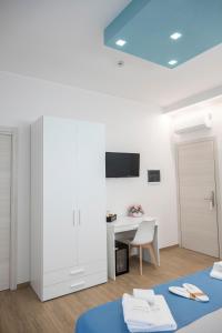 a white room with a desk and a table with a chair at B&B Melavì in Lizzano