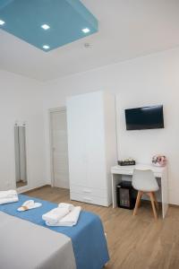 a bedroom with two beds and a desk and a tv at B&B Melavì in Lizzano