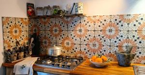 a kitchen with a stove and a bowl of oranges at Tite Case Désirée in Petite Île +15 photos
