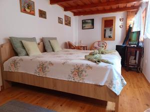 a bedroom with a bed with a teddy bear on it at Fenyő Kuckó in Bodony