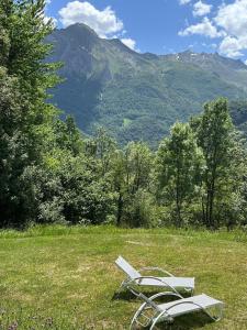 a white bench sitting in a field with mountains in the background at Independent and comfortable room in Arrens-Marsous +5 photos