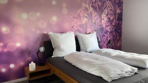 a bedroom with two white pillows and a purple wall at Haus Blumenglück 2.0 in Herscheid