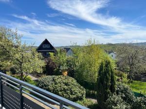a house with a fence and some bushes and trees at Haus Blumenglück 2.0 in Herscheid