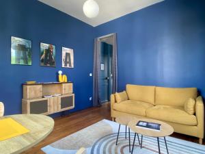 a living room with a couch and a table at Les LOTUS de BELLE-YLE in Yvré-lʼÉvêque