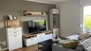 a living room with a couch and a television at Haus Blumenglück 2.0 in Herscheid