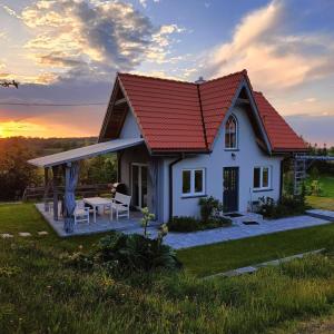 a small white house with a red roof at Domek letniskowy in Kolno