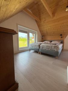 a bedroom with two beds and a large window at Domek letniskowy in Kolno