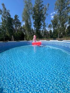 a person in a red raft in a swimming pool at Chatka u Radka in Szczodrowo