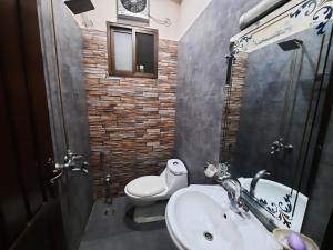 a bathroom with a white toilet and a sink at Prime Apartments in Gujrānwāla +20 photos