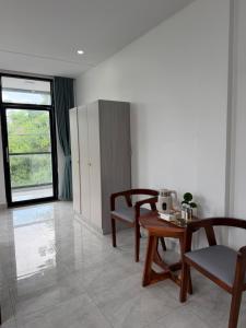 a living room with chairs and a table and a window at J&Q Hotel in Sihanoukville
